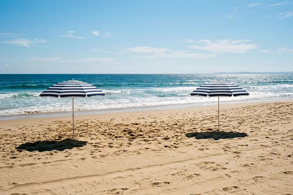 The same beach with the middle umbrella and its shadow removed, the other two unchanged