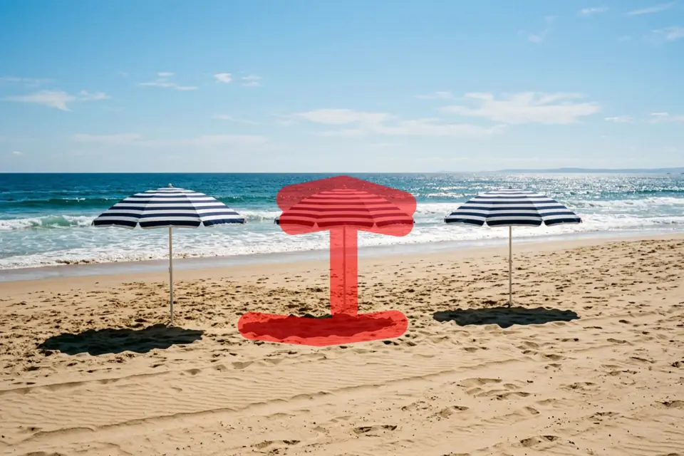 Beach with three striped umbrellas, the middle one brushed over in red