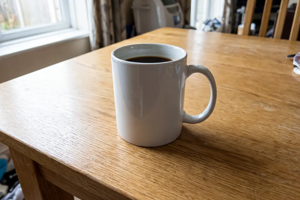 The same mug on a clean wooden table after removing the clutter